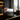 A Ferraux Clay Mask sitting on a white and black cosmetplaced on a dark marble desk in a modern office setting with a city view window and brown leather chair.